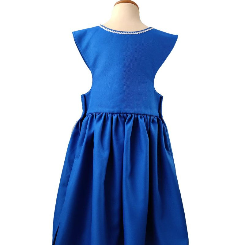 Back view of the royal blue pinafore dress on a stand against a white background.