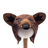 Front view of the brown bear hat on a stand against a plain white background.