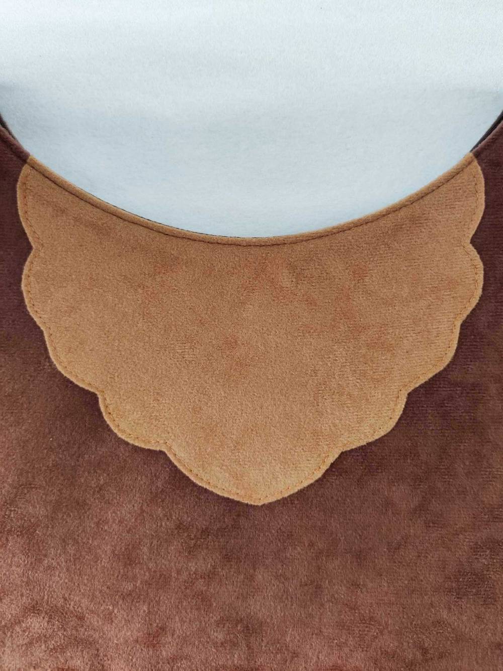 Applique detail on the front of the brown bear tabard.