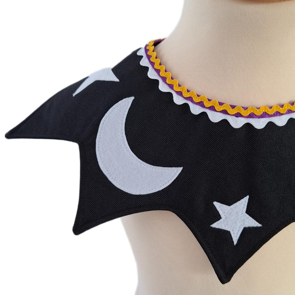 Close up of front view of the celestial moon and stars kids costume collar in midnight black on a stand against a white background.
