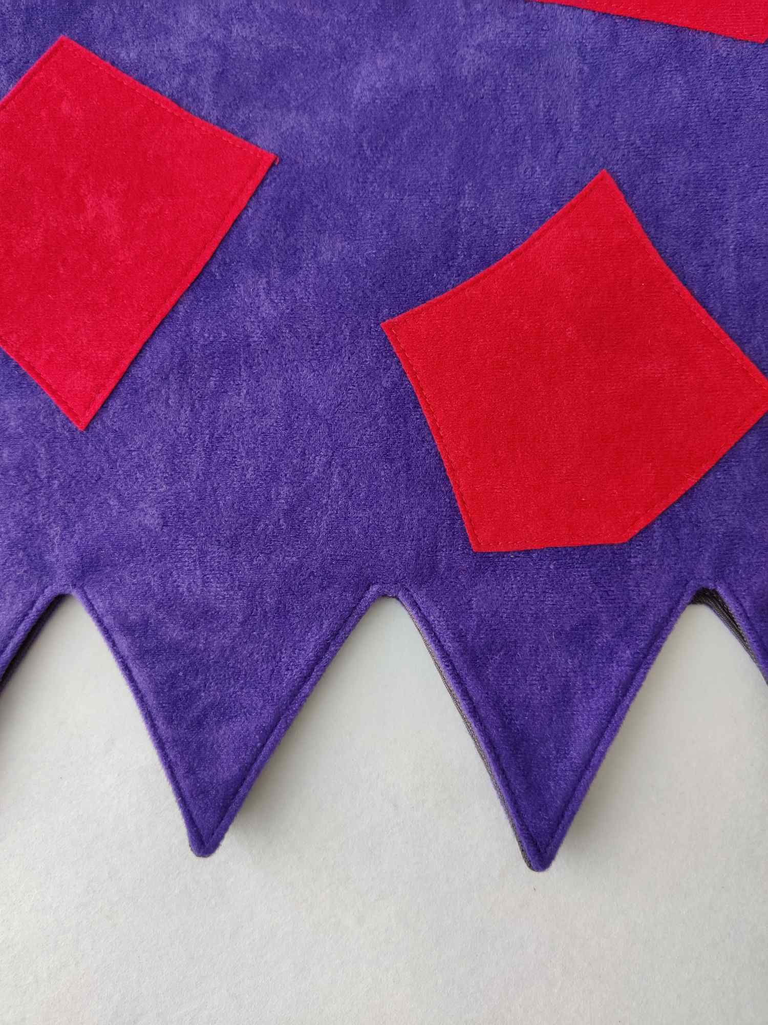 Close up of applique detail and zig zag edge of the green & purple troll tabard