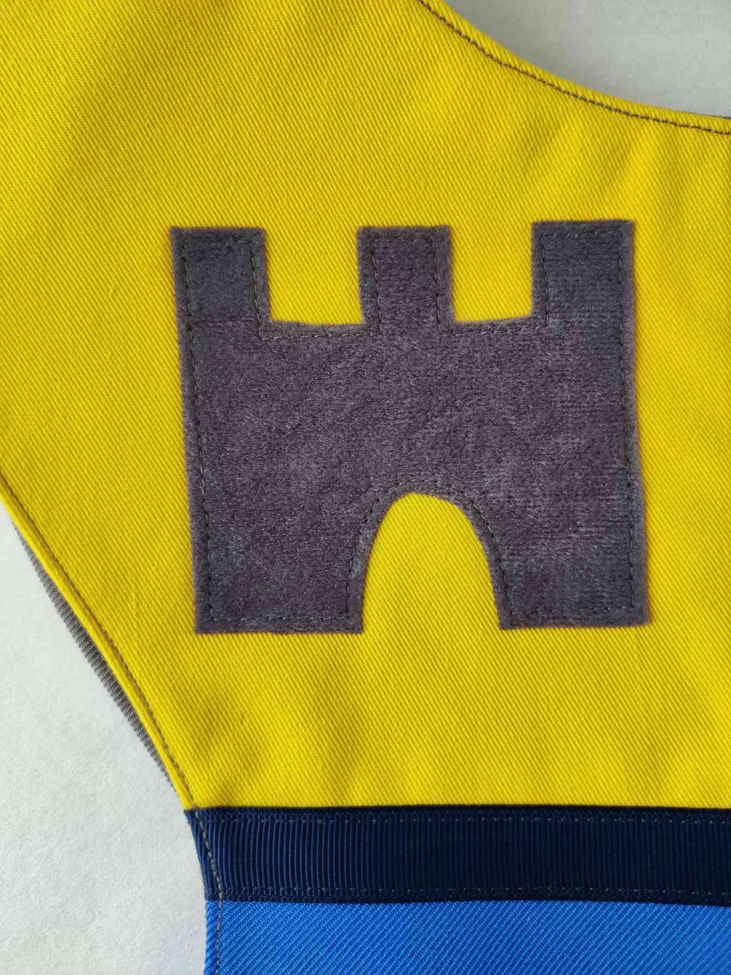 Close up of appliqued castle design on the knight tabard