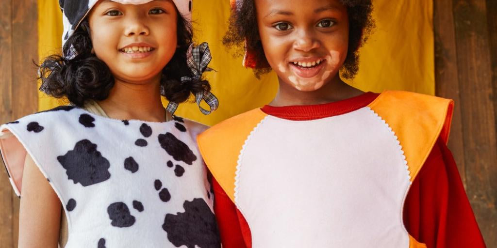 Two children in animal costumes standing next to each other outdoors.