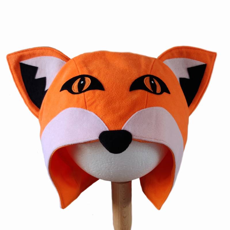 Front view of the red fox hat on a stand against a white background.