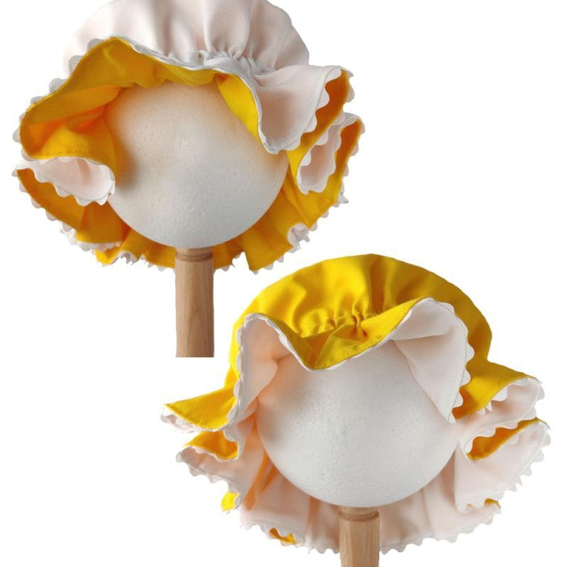 Front view showing both white side and yellow side of the reversible mob cap displayed on stands against a plain white background.