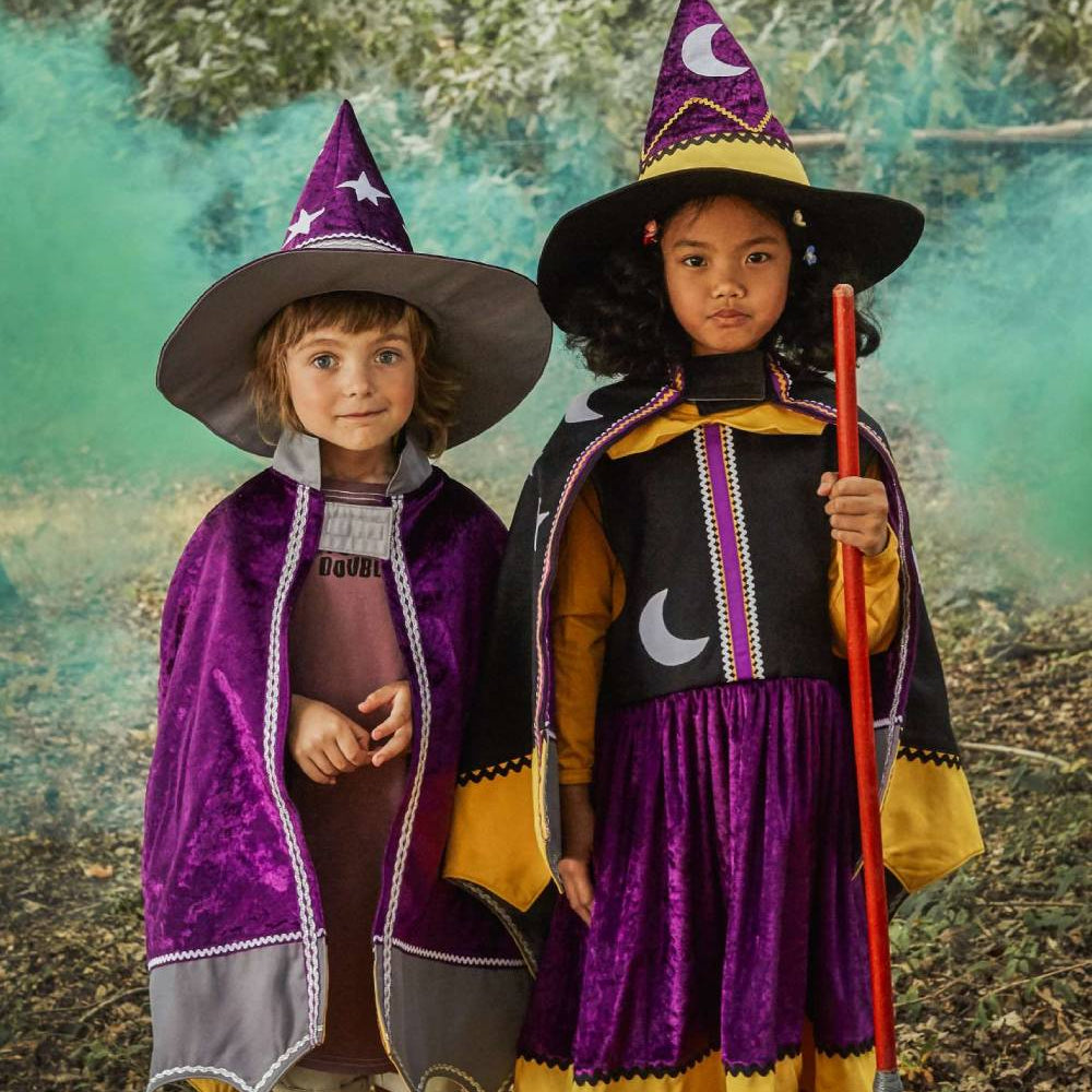 Girl and boy wearing the witch hat and cape and the wizard hat and cape.