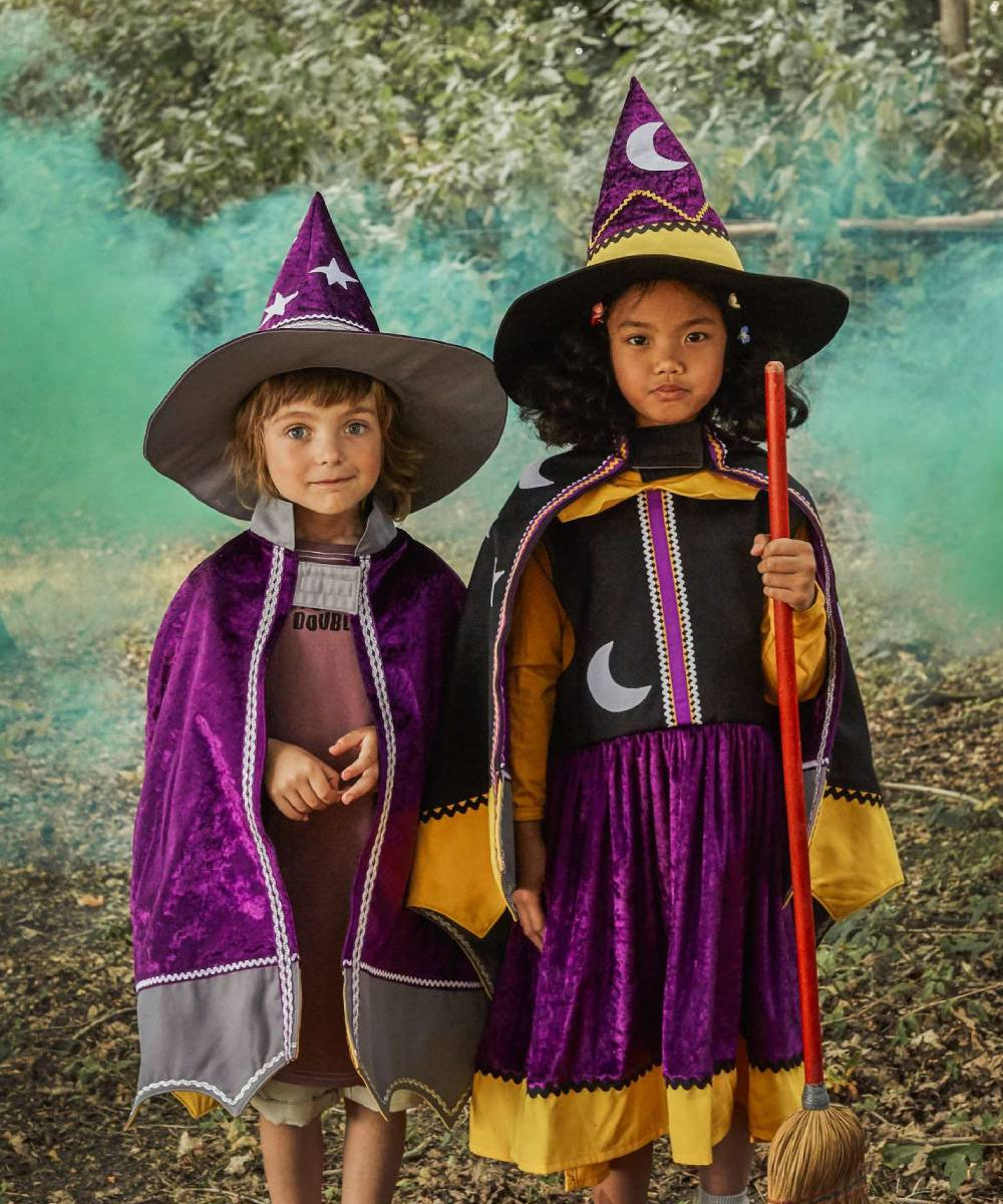 Girl and boy wearing the witch hat and cape and the wizard hat and cape.