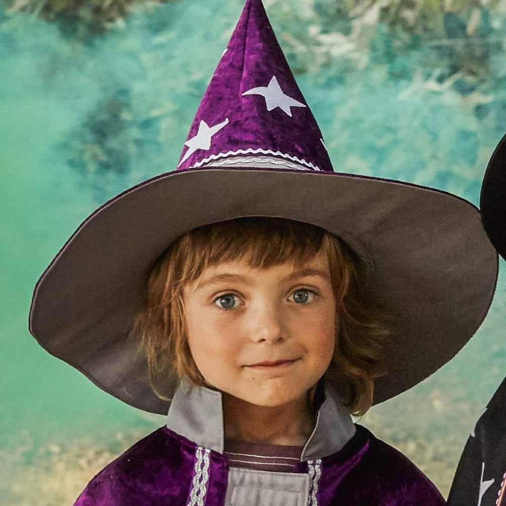 Boy wearing the starry wizard hat and witch wizard cape.