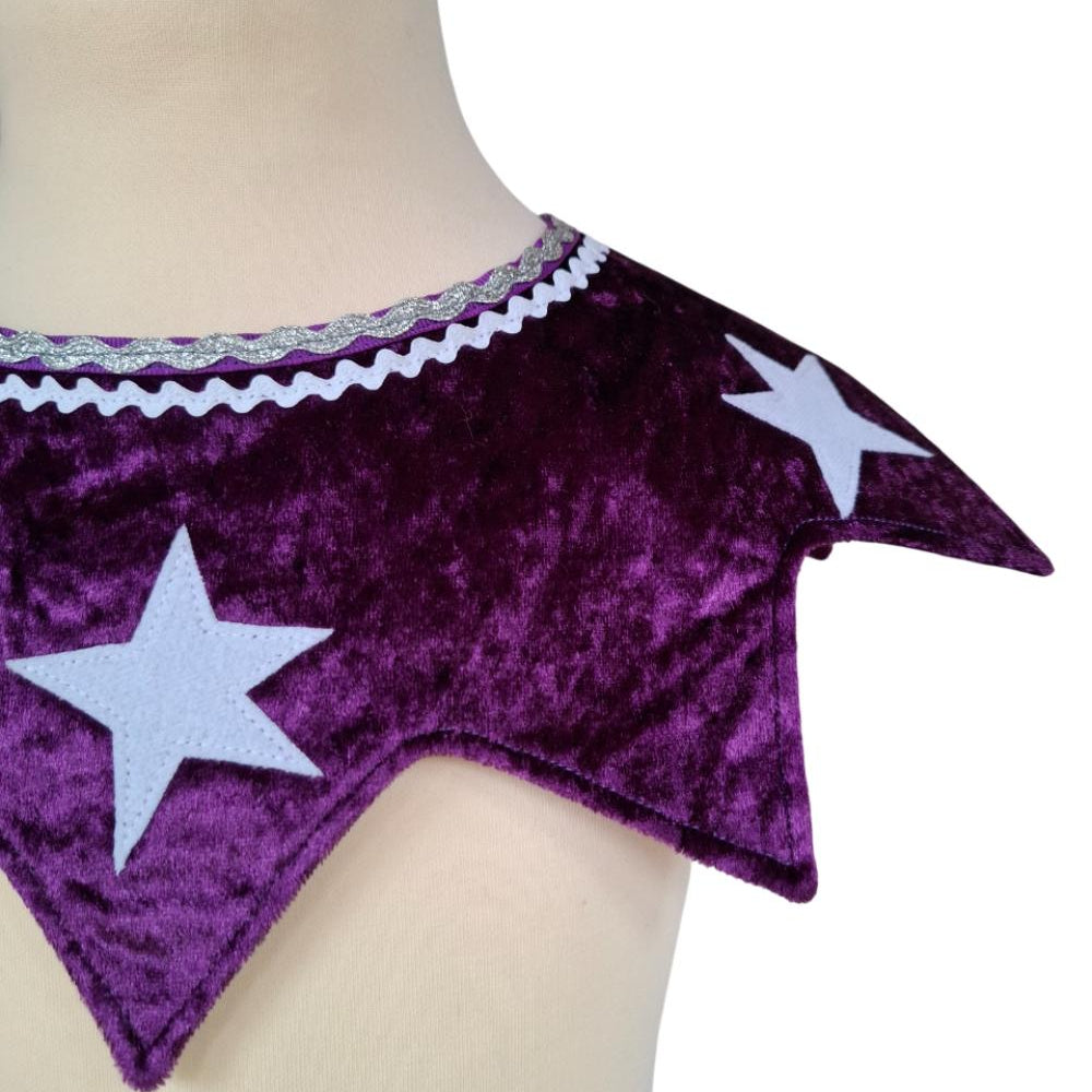 Close up of front view of the twinkling stars kids costume collar in purple on a stand against a white background.